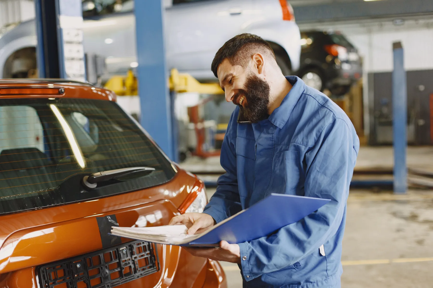 Mecánico revisando el motor de un vehículo con el cofre abierto